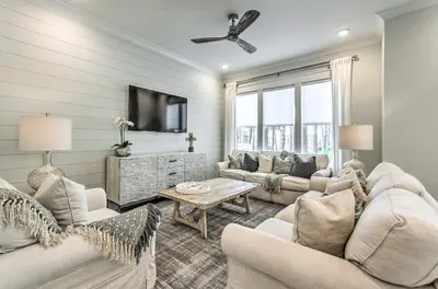 a living room with white furniture and a tv at Always Saturday Prominence Resort Townhome! in Inlet Beach