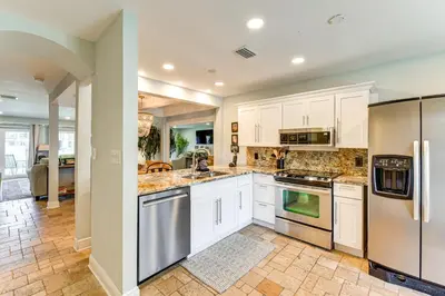 a kitchen with white cabinets and stainless steel appliances at Seaside Panama City Beach Condo with Outdoor Pool! in Panama City Beach