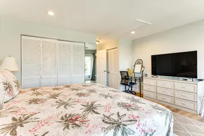 a bedroom with a large bed and a flat screen tv at Seaside Panama City Beach Condo with Outdoor Pool! in Panama City Beach