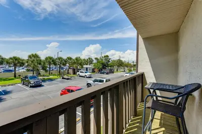 a balcony with a chair and a parking lot at Seaside Panama City Beach Condo with Outdoor Pool! in Panama City Beach