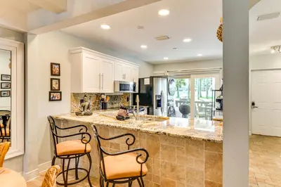 a kitchen with a large island with two stools at Seaside Panama City Beach Condo with Outdoor Pool! in Panama City Beach