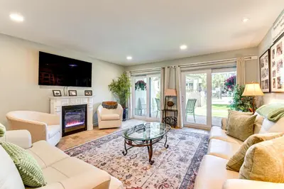 a living room with white furniture and a fireplace at Seaside Panama City Beach Condo with Outdoor Pool! in Panama City Beach