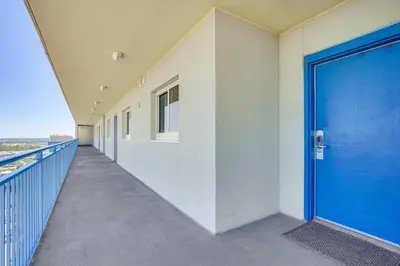 a corridor of a building with a blue door at Beachfront Panama City Condo Walk to Pier Park! in Panama City Beach