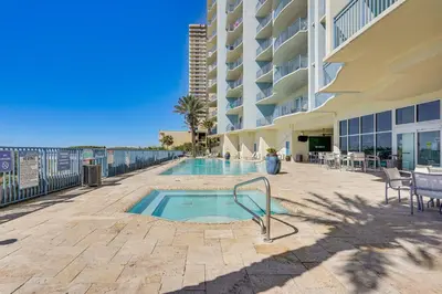 a swimming pool in front of a building at Beachfront Panama City Condo Walk to Pier Park! in Panama City Beach