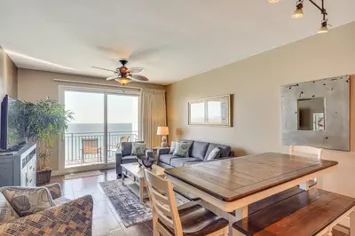 a living room with a table and a couch at Beachfront Panama City Condo Walk to Pier Park! in Panama City Beach
