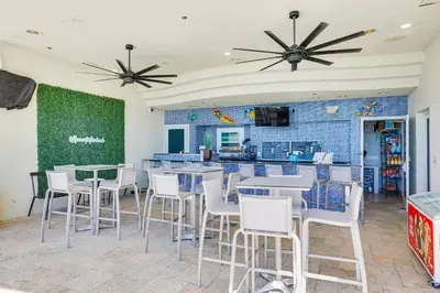 a restaurant with tables and chairs and a counter at Beachfront Panama City Condo Walk to Pier Park! in Panama City Beach