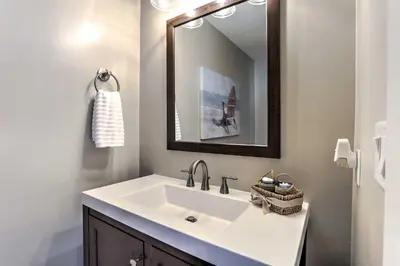 a bathroom with a white sink and a mirror at Coastal Florida Abode with Pool Access and Ocean Views in Panama City Beach