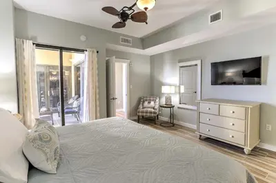a bedroom with a bed and a ceiling fan at Coastal Florida Abode with Pool Access and Ocean Views in Panama City Beach