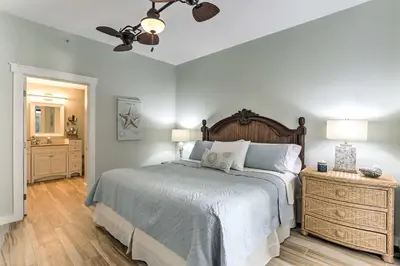 a bedroom with a bed and a ceiling fan at Coastal Florida Abode with Pool Access and Ocean Views in Panama City Beach