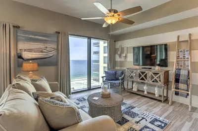 a living room with a couch and a flat screen tv at Coastal Florida Abode with Pool Access and Ocean Views in Panama City Beach