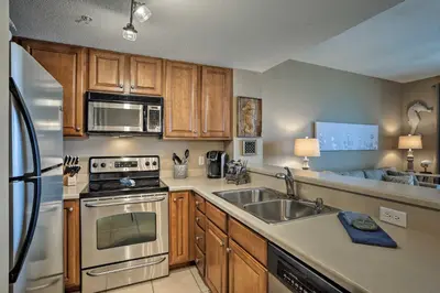 a kitchen with a sink and a stove at Resort Pool, Gym and Hot Tub Beachfront PCB Condo! in Panama City Beach