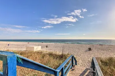 a beach with a blue staircase leading to the ocean at Resort Pool, Gym and Hot Tub Beachfront PCB Condo! in Panama City Beach