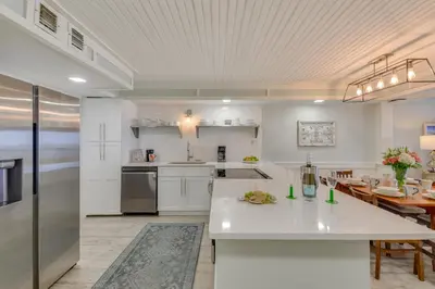 a large kitchen with white cabinets and a table at Oceanfront PCB Condo with Beach Access and 2 Pools in Panama City Beach