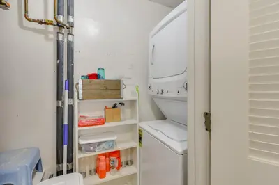 a small kitchen with a white refrigerator with shelves at Oceanfront PCB Condo with Beach Access and 2 Pools in Panama City Beach