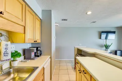 a kitchen with wooden cabinets and a sink at Oceanfront Panama City Beach Condo with Balcony! in Panama City Beach