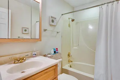 a white bathroom with a sink and a shower at Oceanfront Panama City Beach Condo with Balcony! in Panama City Beach