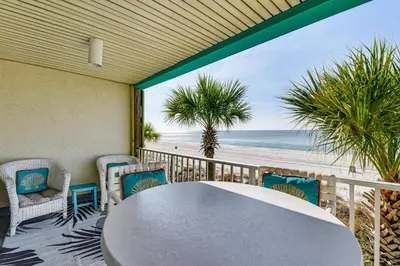 a table and chairs on a balcony with the beach at Oceanfront Panama City Beach Condo with Balcony! in Panama City Beach