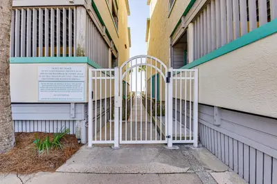 a white gate in front of a building at Oceanfront Panama City Beach Condo with Balcony! in Panama City Beach
