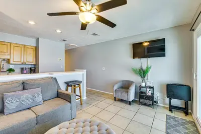 a living room with a couch and a tv at Oceanfront Panama City Beach Condo with Balcony! in Panama City Beach