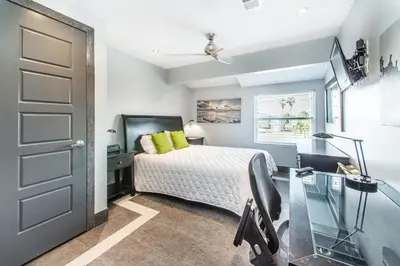 a bedroom with a bed and a desk and a door at Klaus House 1 in Panama City Beach