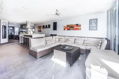 a living room with white furniture and a bar at Klaus House 1 in Panama City Beach