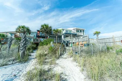 a house on the beach next to a fence at Klaus House 1 in Panama City Beach