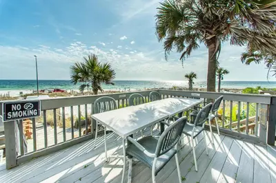 a table and chairs on a deck with the beach at Klaus House 1 in Panama City Beach