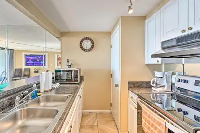 a kitchen with stainless steel appliances and a clock on the wall at Chic PCB Condo with Pool Access and Beachfront Balcony in Panama City Beach