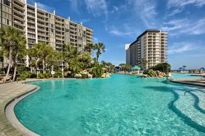 a swimming pool in front of a resort at Chic PCB Condo with Pool Access and Beachfront Balcony in Panama City Beach