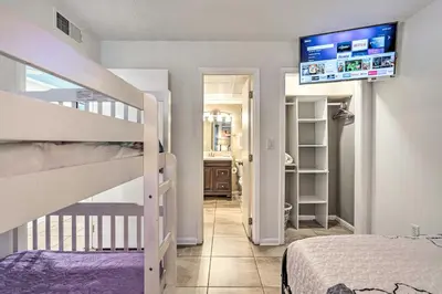 a bedroom with a bunk bed and a staircase at Chic PCB Condo with Pool Access and Beachfront Balcony in Panama City Beach