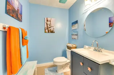 a blue bathroom with a toilet and a sink at PCB Studio with Private Patio Steps to Beach! in Panama City Beach
