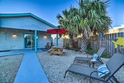 a patio with chairs and an umbrella and a bench at PCB Studio with Private Patio Steps to Beach! in Panama City Beach