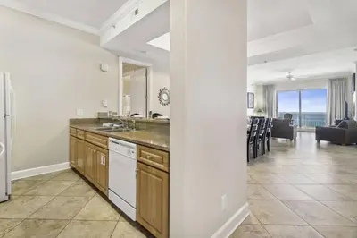 a kitchen with a sink and a living room at Ocean Ritz 2101 (4/4) in Panama City Beach