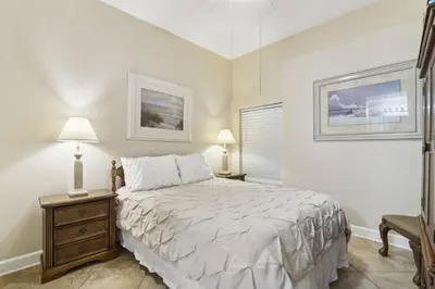 a bedroom with a bed and two lamps and a chair at Ocean Ritz 2101 (4/4) in Panama City Beach