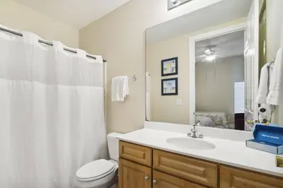 a bathroom with a sink and a toilet and a mirror at Ocean Ritz 2101 (4/4) in Panama City Beach