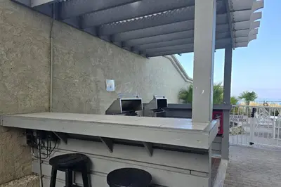 a patio with a bar with stools and a table at Ocean Ritz 2101 (4/4) in Panama City Beach
