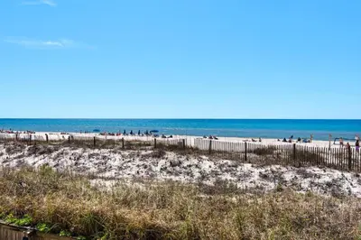 a beach with a fence and people on the beach at Sugar Beach C-17 (2/2) in Panama City Beach