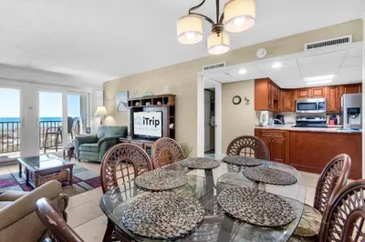 a living room with a dining room table and chairs at Sugar Beach C-17 (2/2) in Panama City Beach
