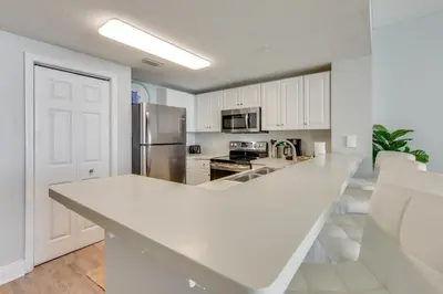 a kitchen with white cabinets and a white counter top at Resort Amenities Beachfront Panama City Condo! in Panama City Beach