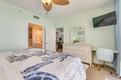 a bedroom with a bed and a desk and a television at Resort Amenities Beachfront Panama City Condo! in Panama City Beach