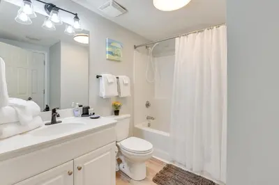 a bathroom with a toilet and a sink and a shower at Resort Amenities Beachfront Panama City Condo! in Panama City Beach