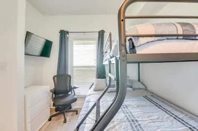 a bedroom with two bunk beds and a desk and a chair at Resort Amenities Beachfront Panama City Condo! in Panama City Beach