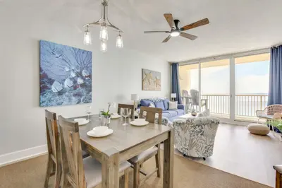 a dining room and living room with a table and chairs at Resort Amenities Beachfront Panama City Condo! in Panama City Beach