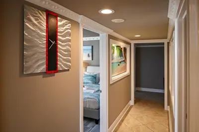 a hallway with a bed and a clock on the wall at Panama City Beach Condo with Balcony and Ocean Views in Panama City Beach