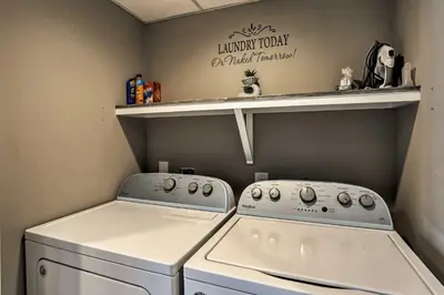 a laundry room with a washer and dryer and a shelf at Panama City Beach Condo with Balcony and Ocean Views in Panama City Beach