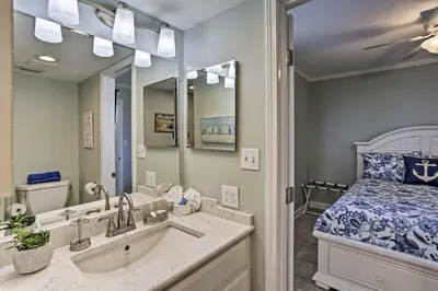 a bathroom with a sink and a bed and a mirror at Bright PCB Condo with Gulf Views and Beach Access! in Panama City Beach