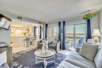 a living room with a couch and a table at Steps to Shore! PCB Resort Condo with Balcony in Panama City Beach