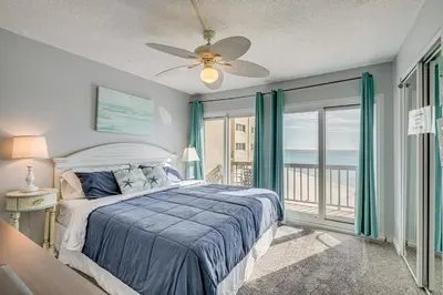 a bedroom with a bed and a ceiling fan at Steps to Shore! PCB Resort Condo with Balcony in Panama City Beach