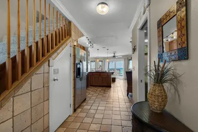 a hallway with a staircase and a table and a hallway with the ocean at Klaus House 3 in Panama City Beach