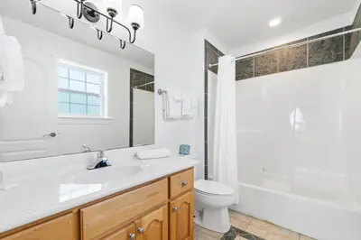 a white bathroom with a sink and a toilet at Panama City Beach House - Sunnyside Up in Panama City Beach